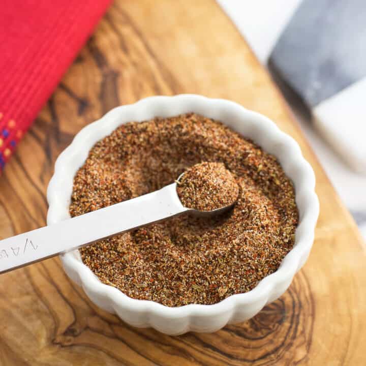 Taco seasoning stirred together in a small bowl with a quarter-teaspoon scoop in it.