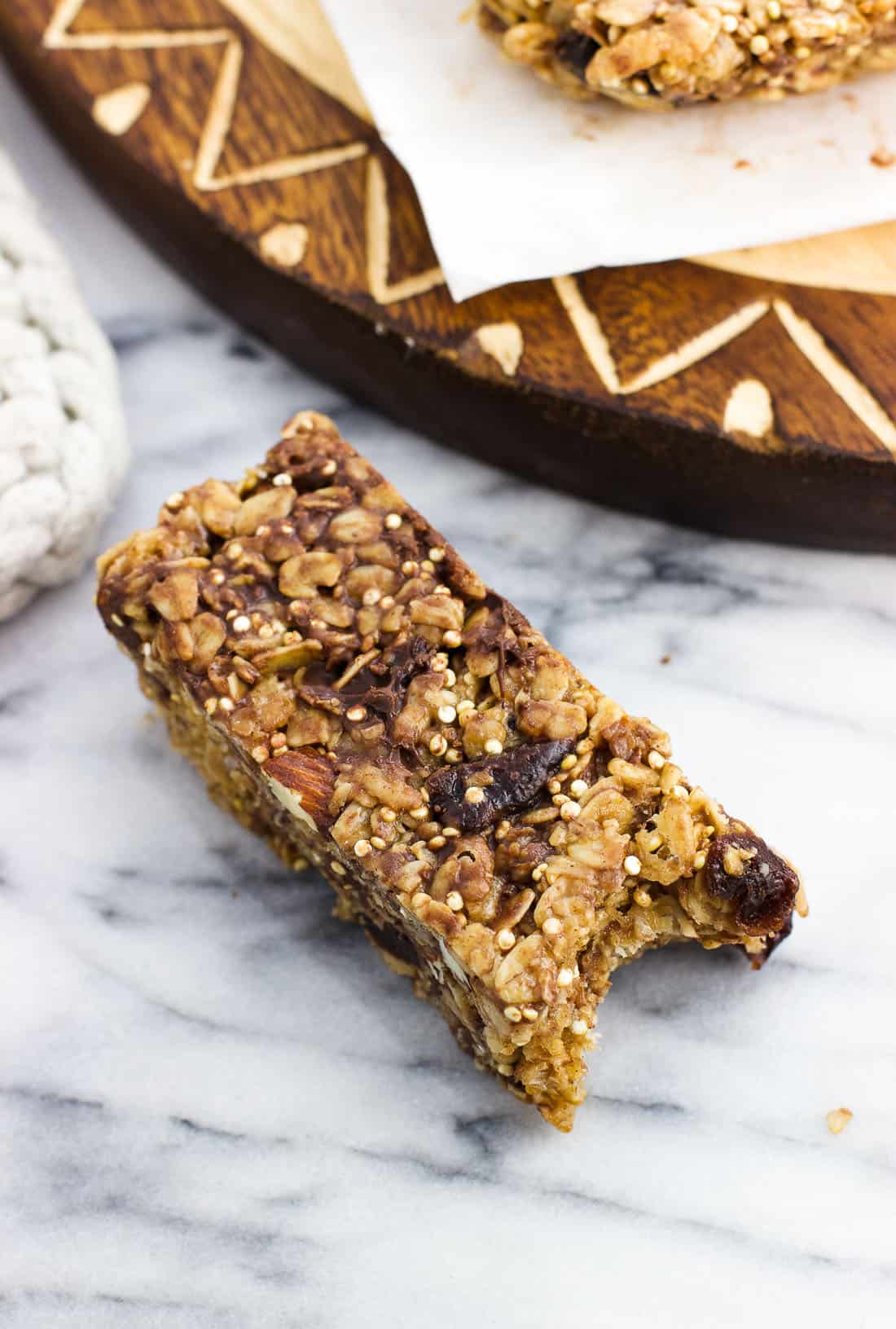 A close-up of a bar with a bite taken out of it on a marble board