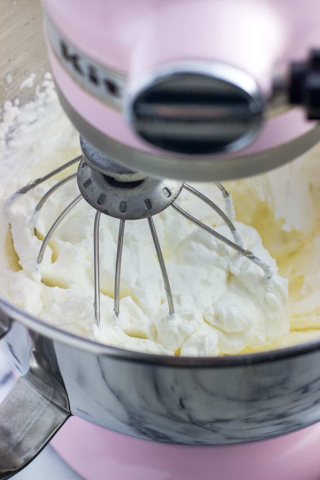 Whipped cream in a stand mixer after it has thickened.