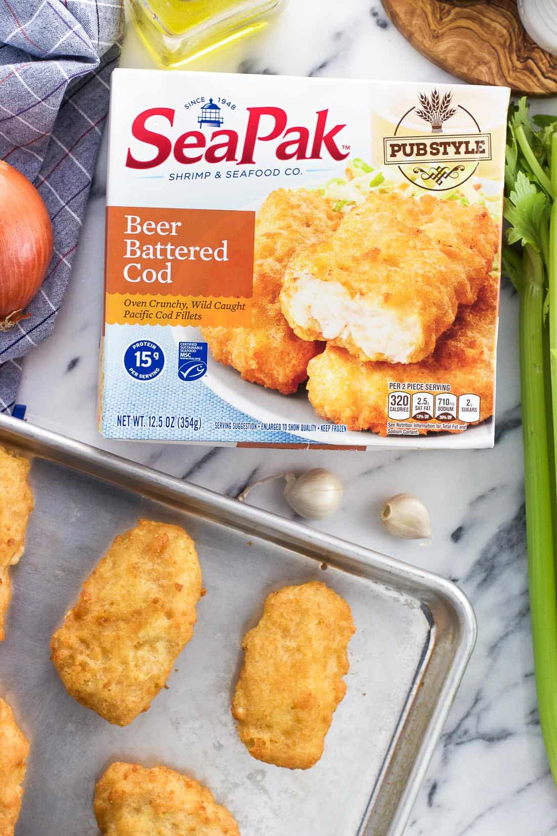 A package of SeaPak beer battered cod next to a tray of cooked cod fillets