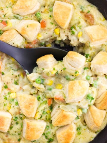 A serving spoon scooped into the skillet pot pie