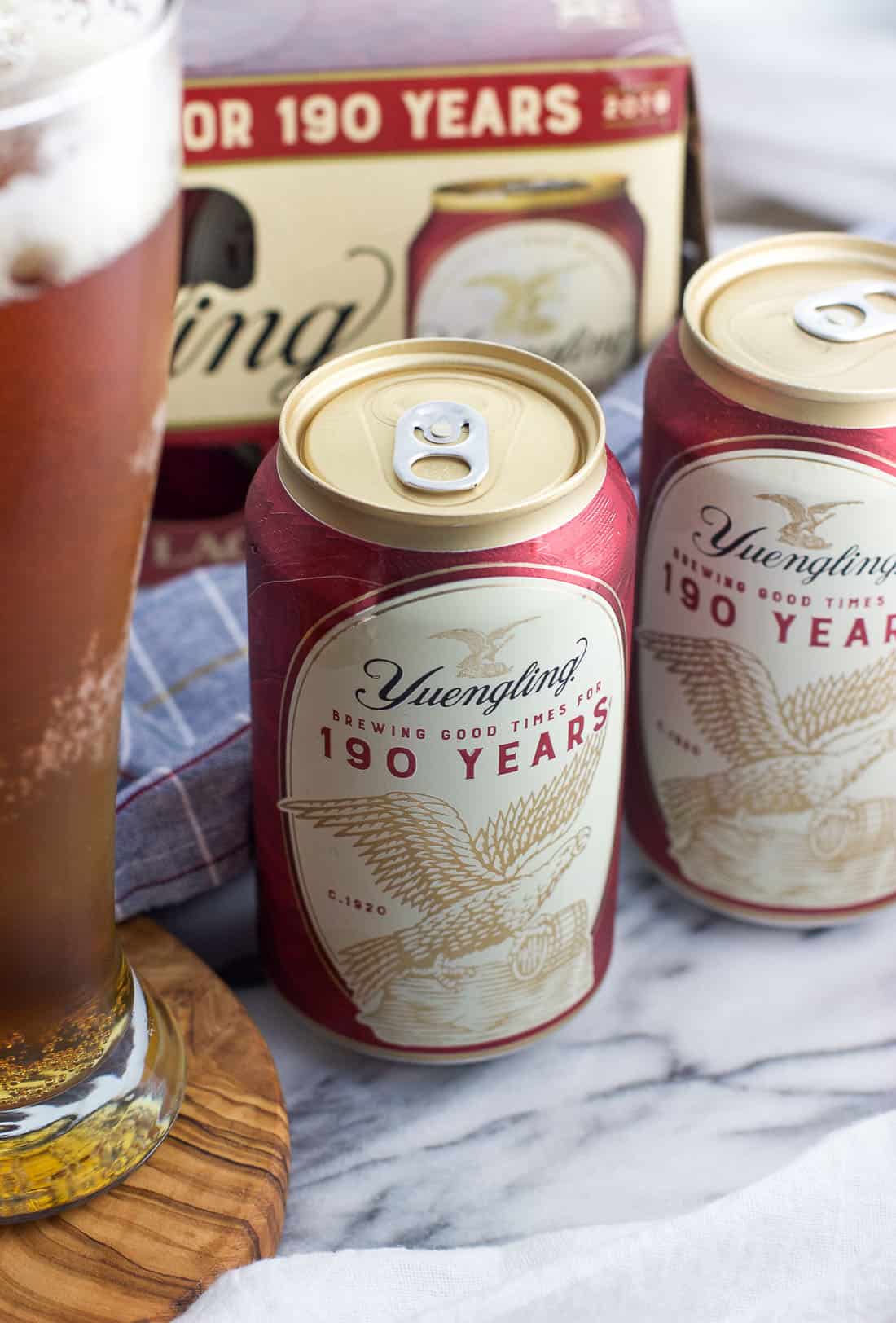 A close-up of Yuengling cans on a marble board.