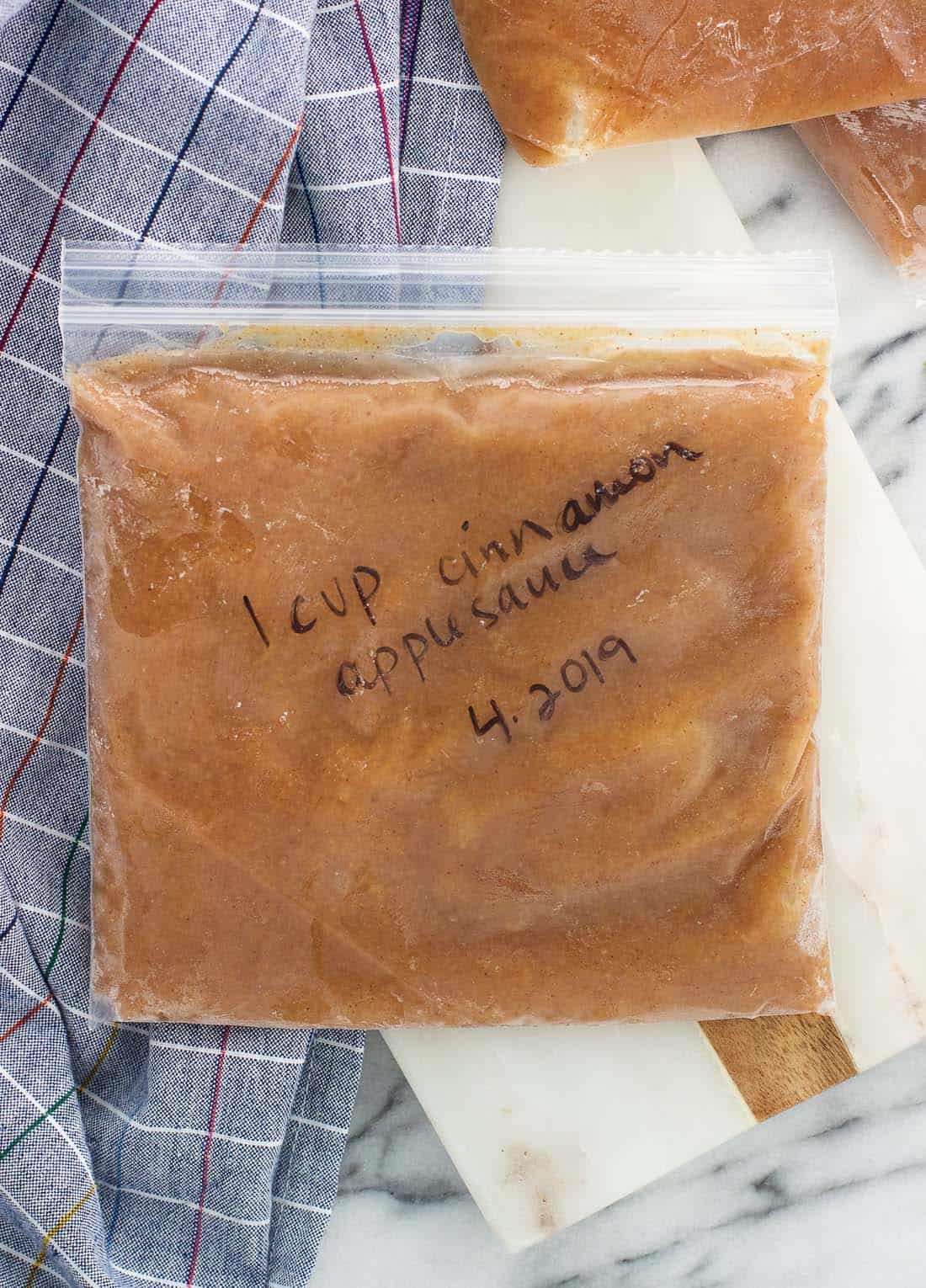 One cup of applesauce frozen flat in a quart-sized plastic bag.