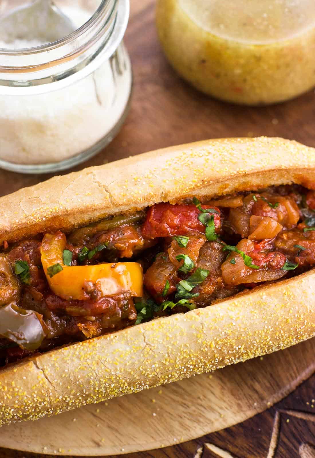 A close up shot of an Italian sausage and peppers sandwich