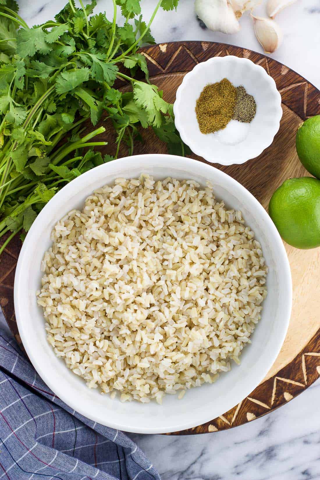 The recipe ingredients, including cooked rice, a bunch of cilantro, limes, and spices.