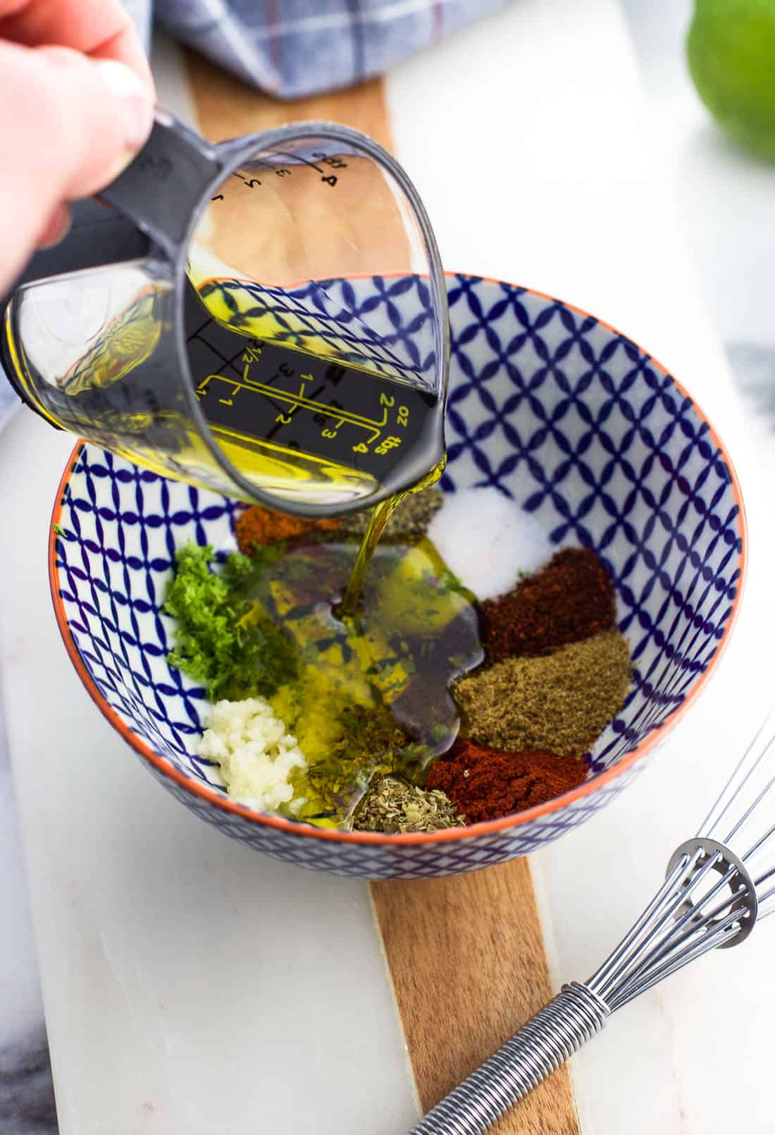 Olive oil being poured into the small bowl with the chili lime seasonings