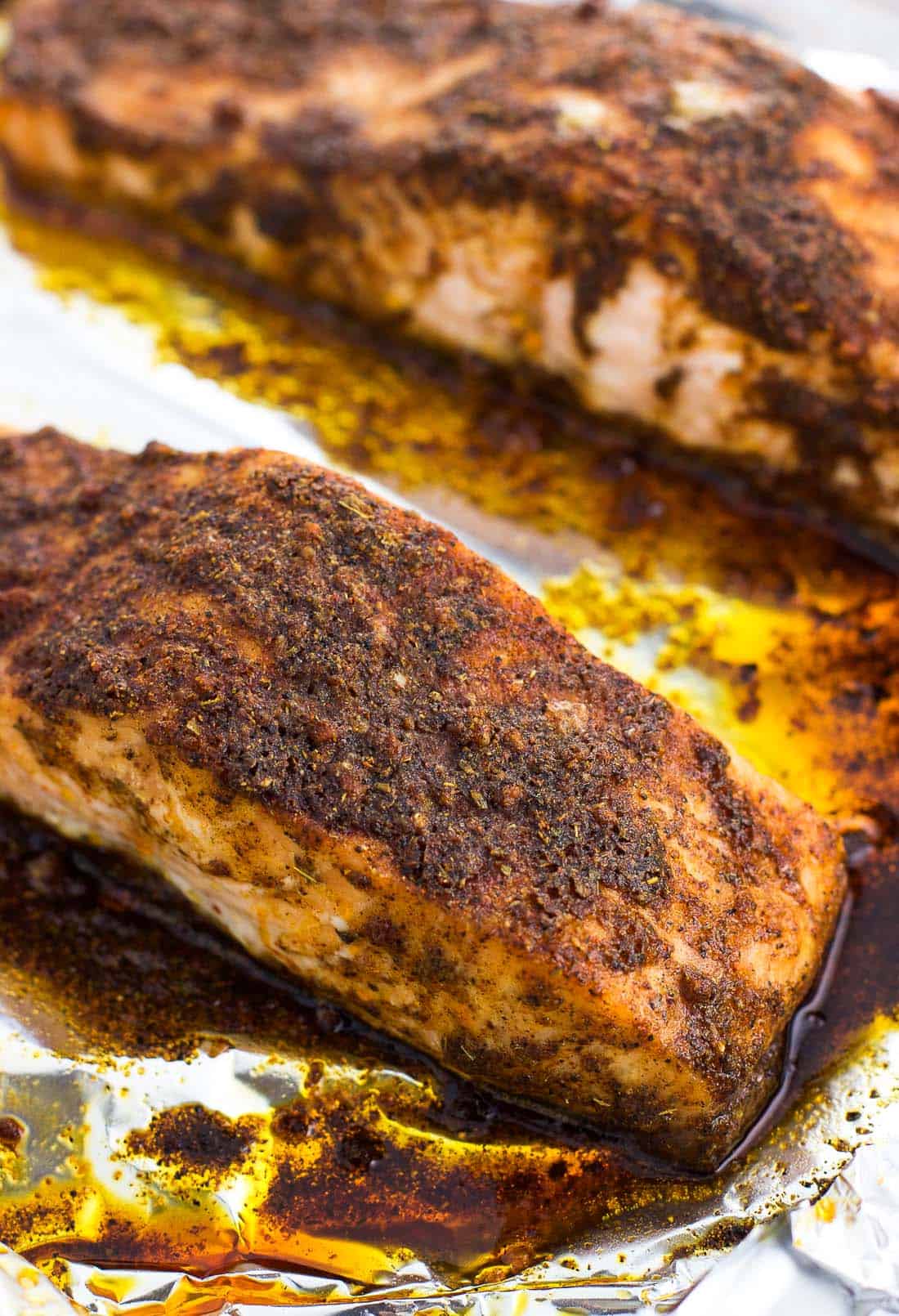 Fully cooked salmon fillets on a foil-lined baking sheet