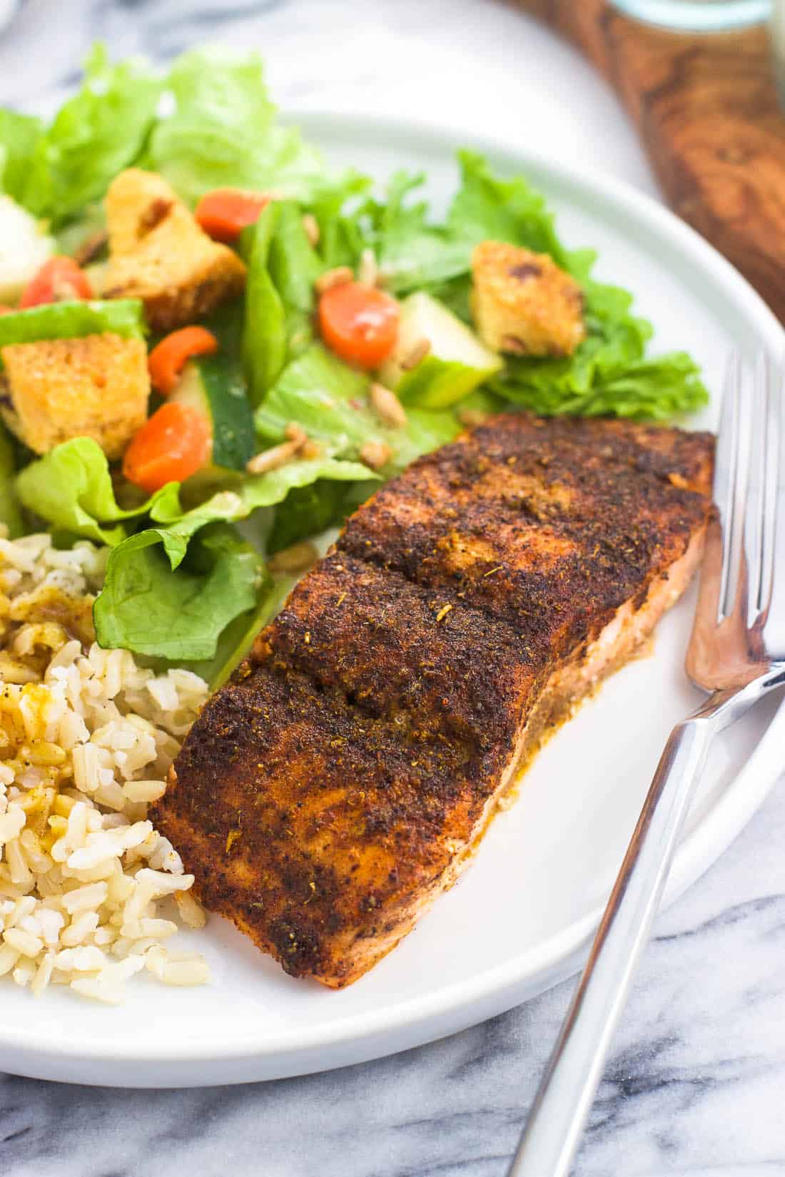 A plate of chili lime salmon, brown rice, and a side salad