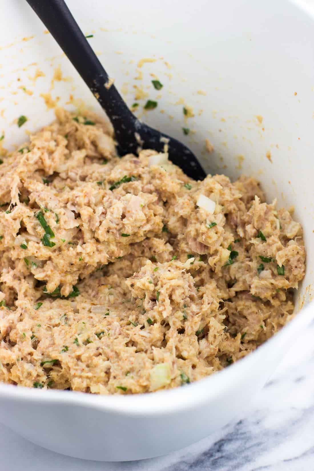 The tuna cake mixture folded together in a bowl before being shaped.