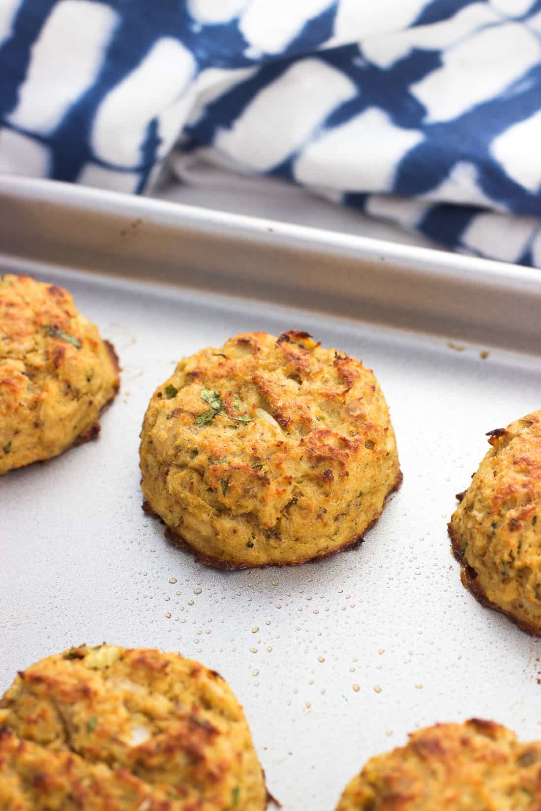 A baked and broiled tuna cake on a baking sheet.