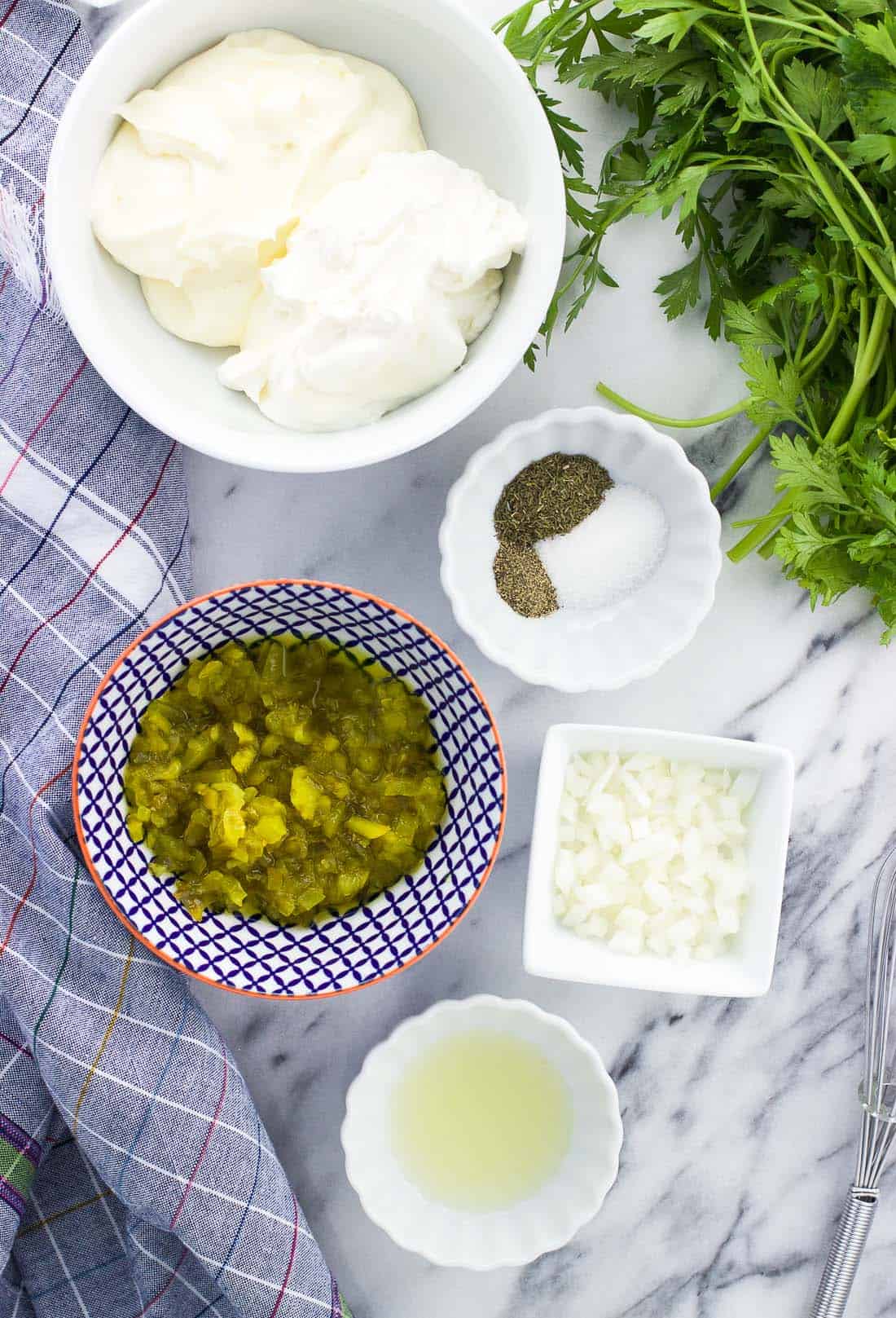 An overhead shot of bowls of the healthy tartar sauce ingredients.