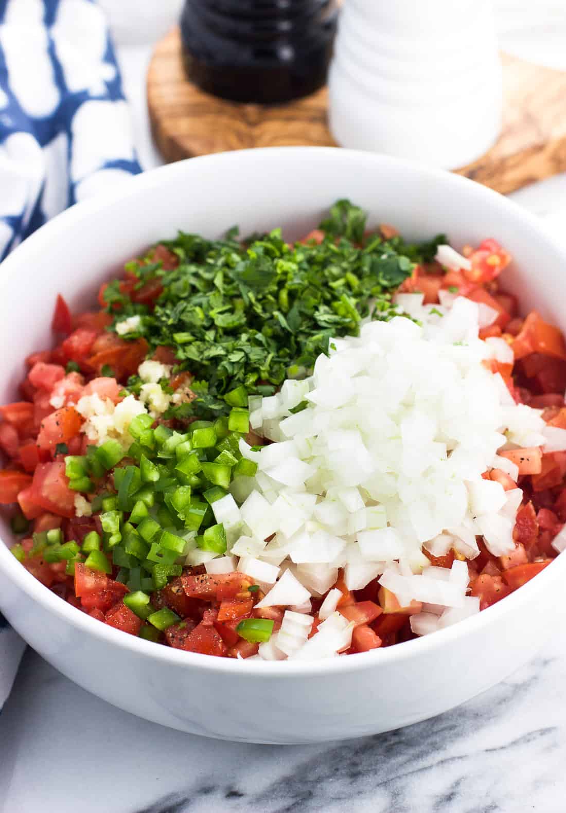 All chopped up pico de gallo ingredients in a bowl ready to be mixed together.