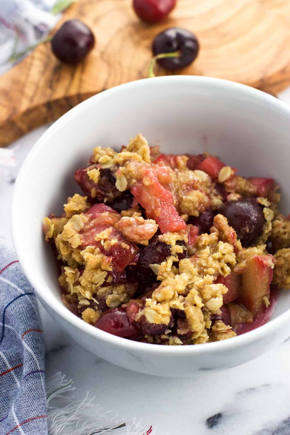 A serving of cherry rhubarb crisp in a bowl