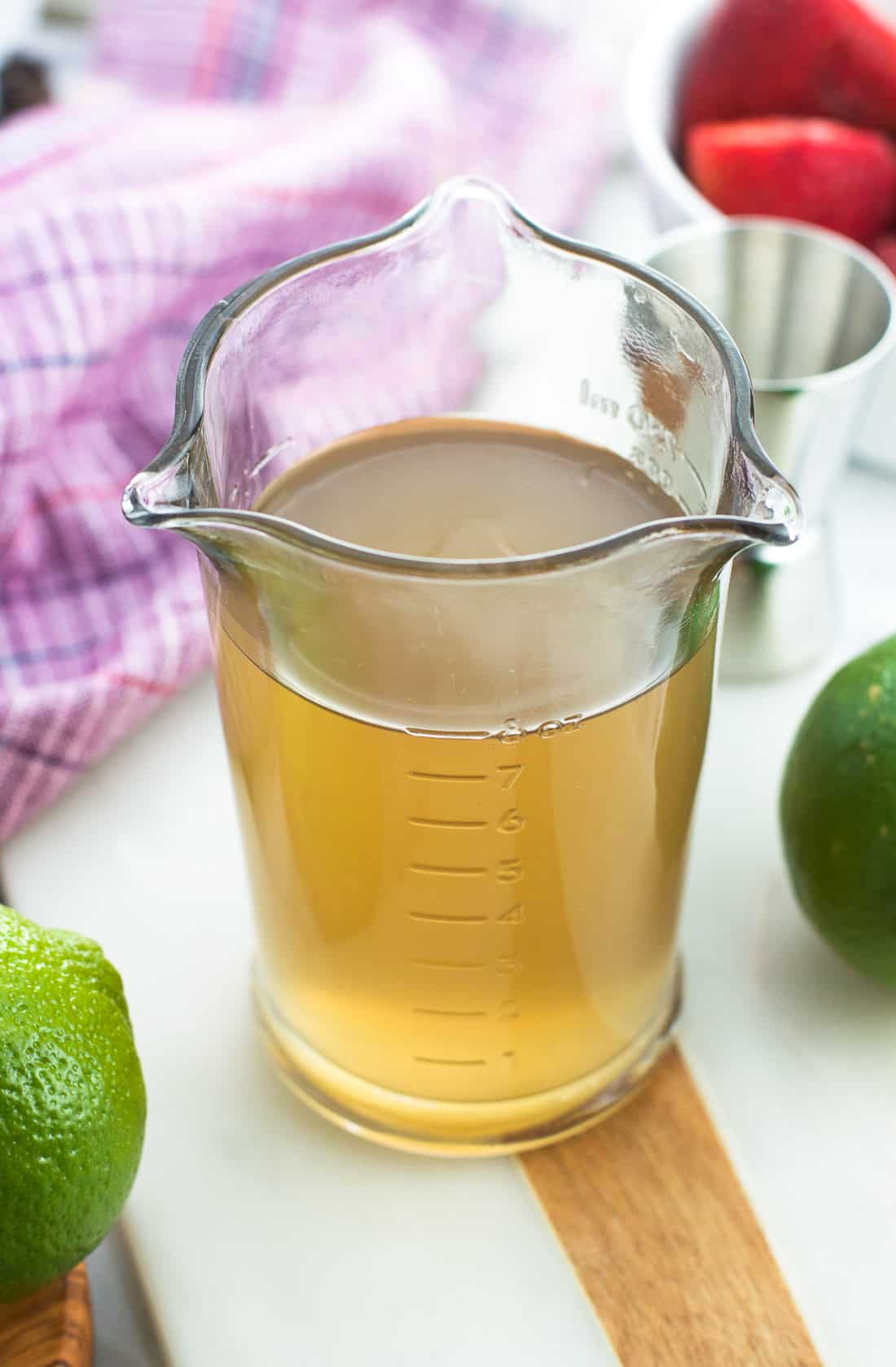 One cup of ginger simple syrup in a glass measuring cup