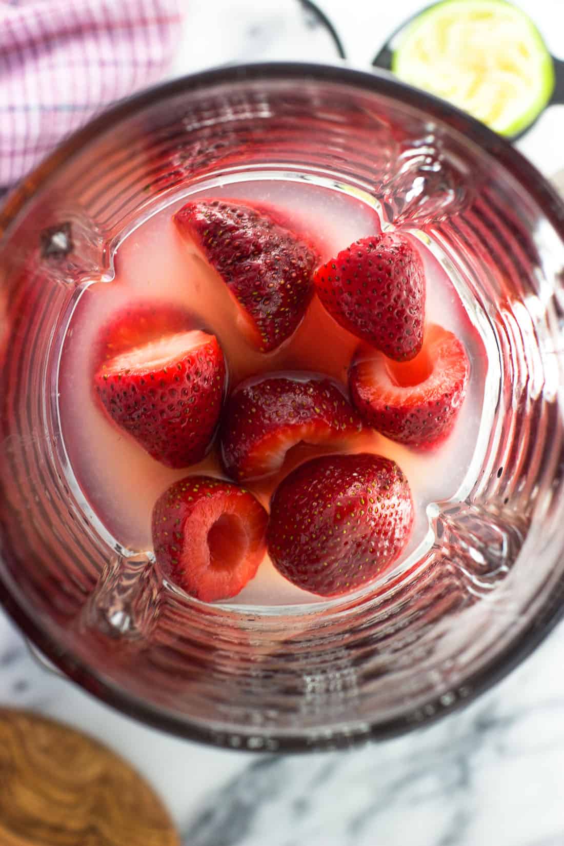 Whole hulled strawberries and the rest of the margarita ingredients in a blender