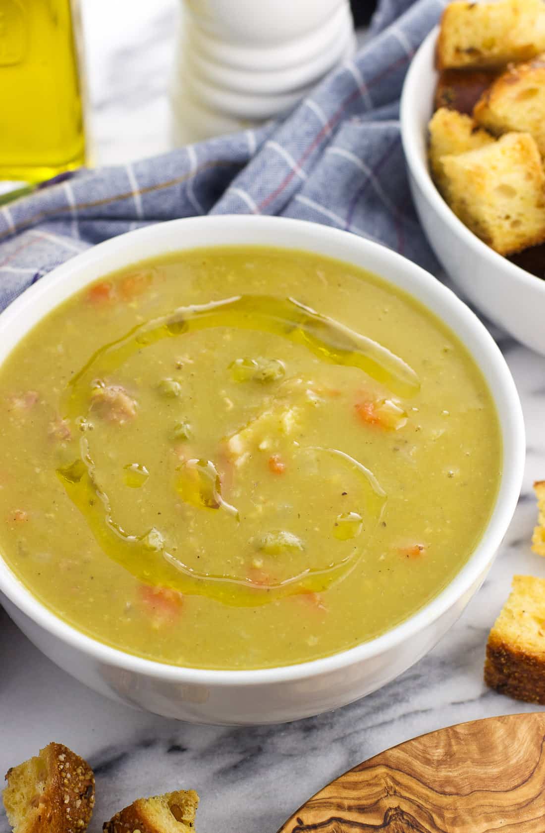 A bowl of Instant Pot split pea soup, topped with a drizzle of olive oil for serving.