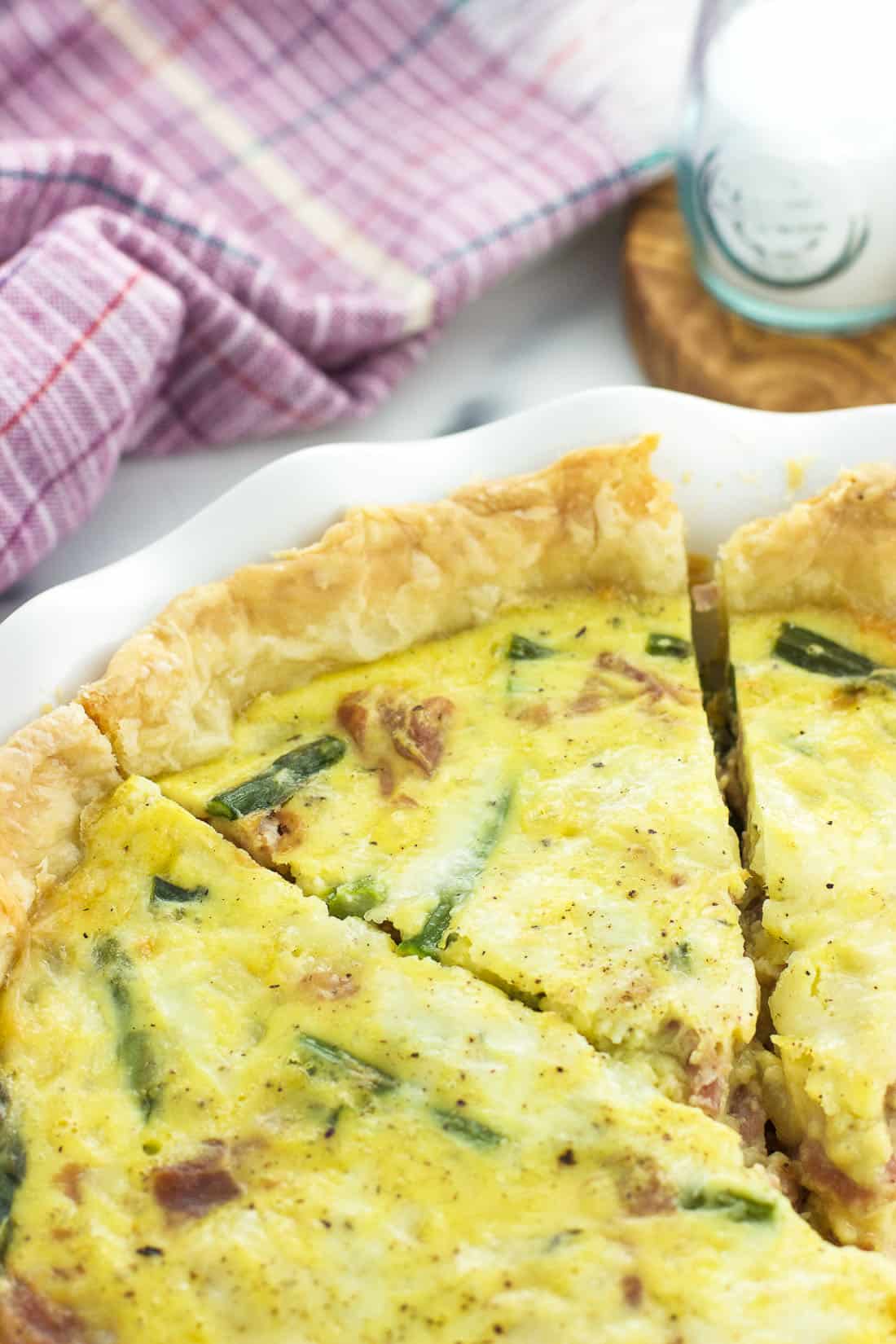 Sliced quiche in a scalloped-edge pie plate.