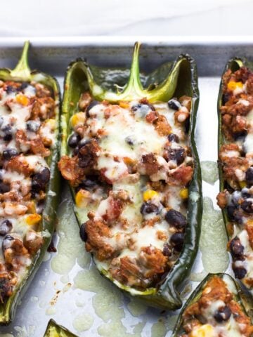 Healthy stuffed poblano peppers on a metal baking sheet