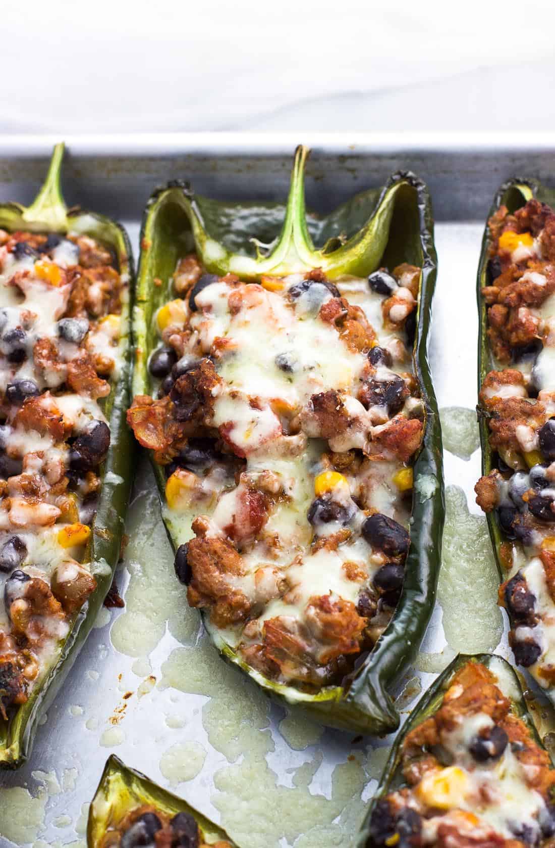 Healthy stuffed poblano peppers on a metal baking sheet.
