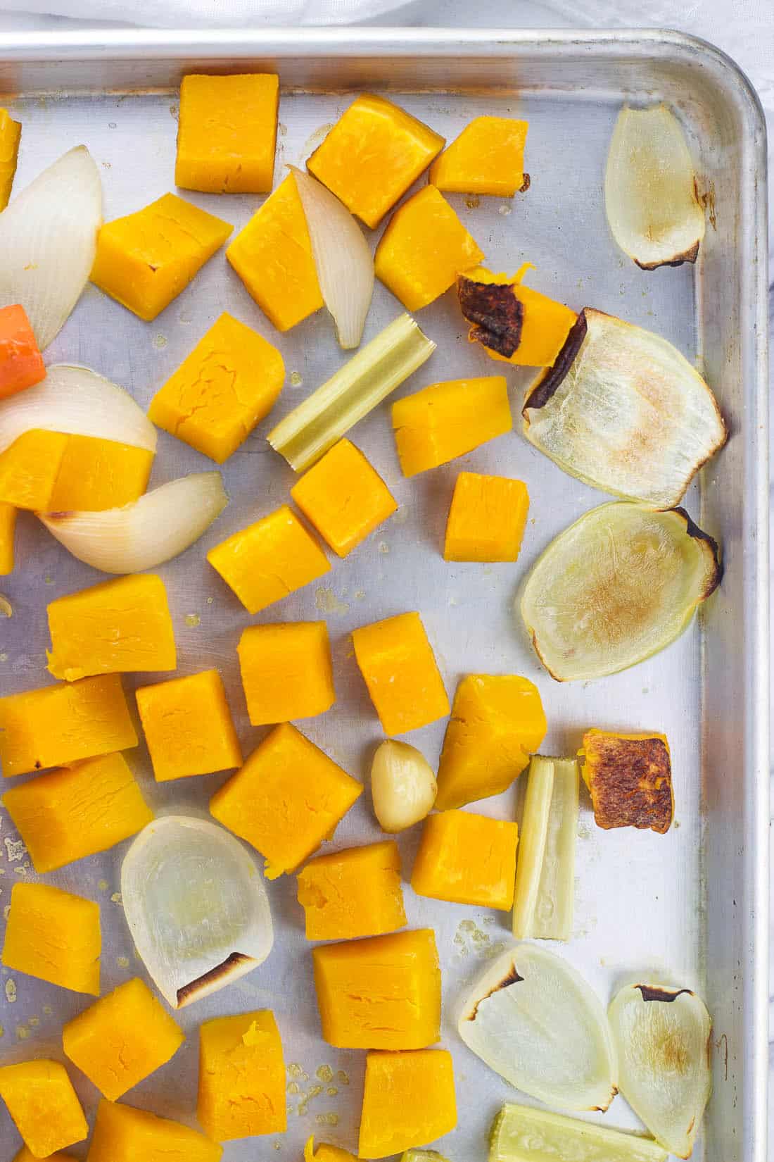 Roasted soup ingredients on a metal baking sheet