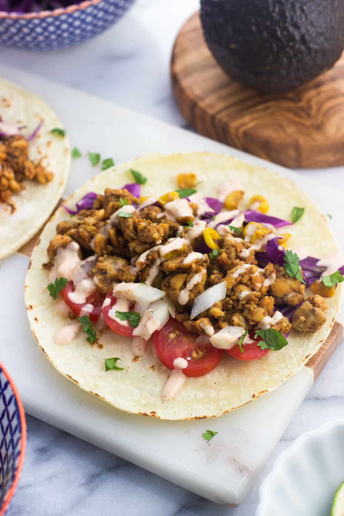 Assembled tacos on a marble serving board