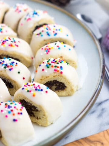 Glazed cucidati lined up next to one another on a serving plate