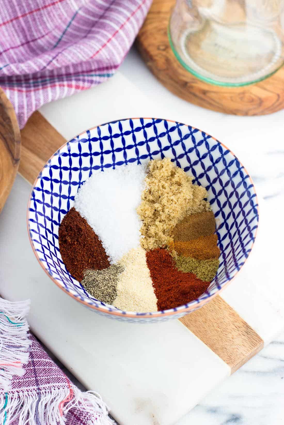 All of the spices for the seasoning rub in a ceramic bowl