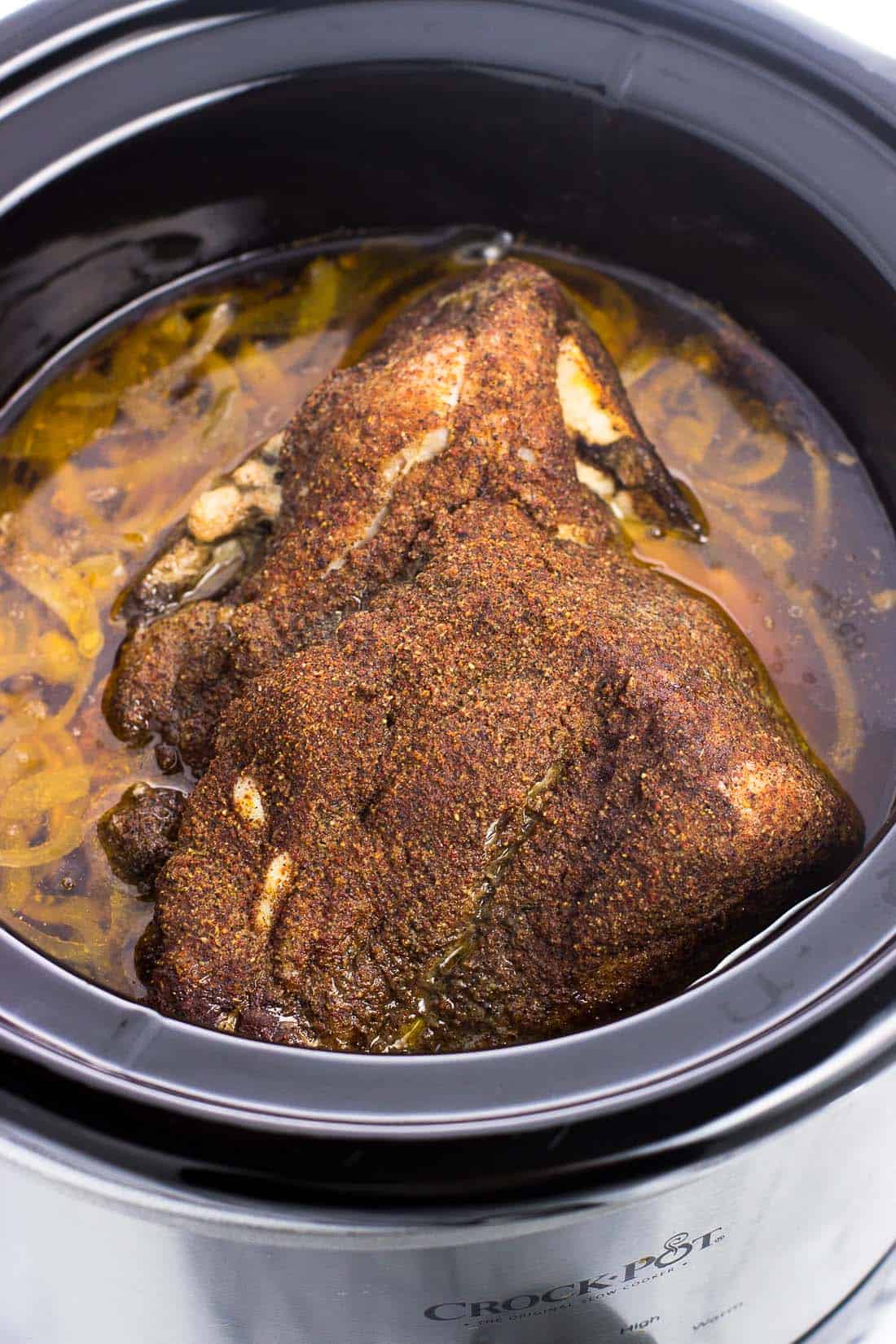 Cooked Boston butt in the slow cooker before being shredded into pulled pork