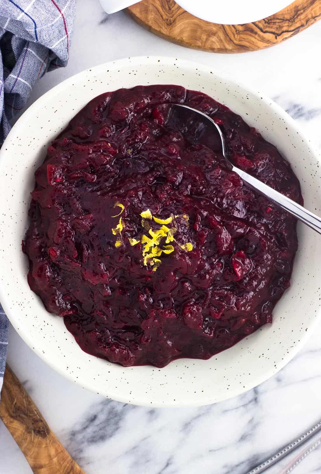 An overhead picture of cranberry sauce in a serving bowl with a spoon