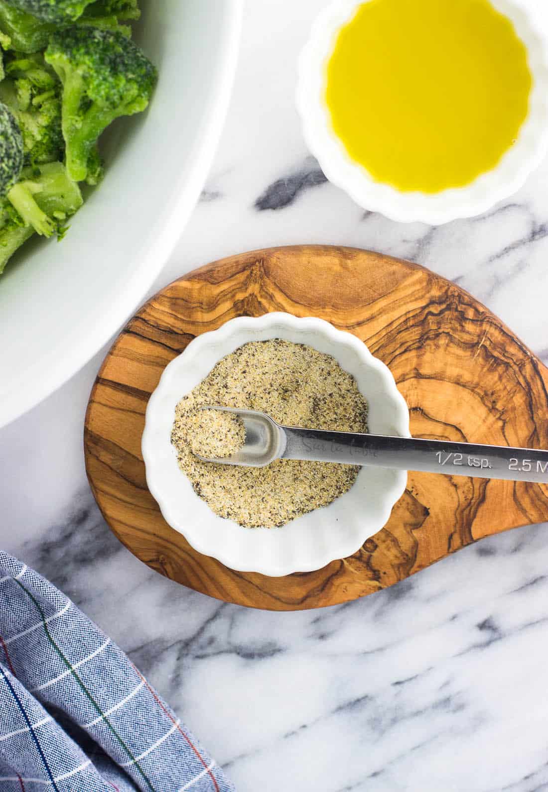 The spices mixed together in a small bowl with a half-teaspoon scoop.