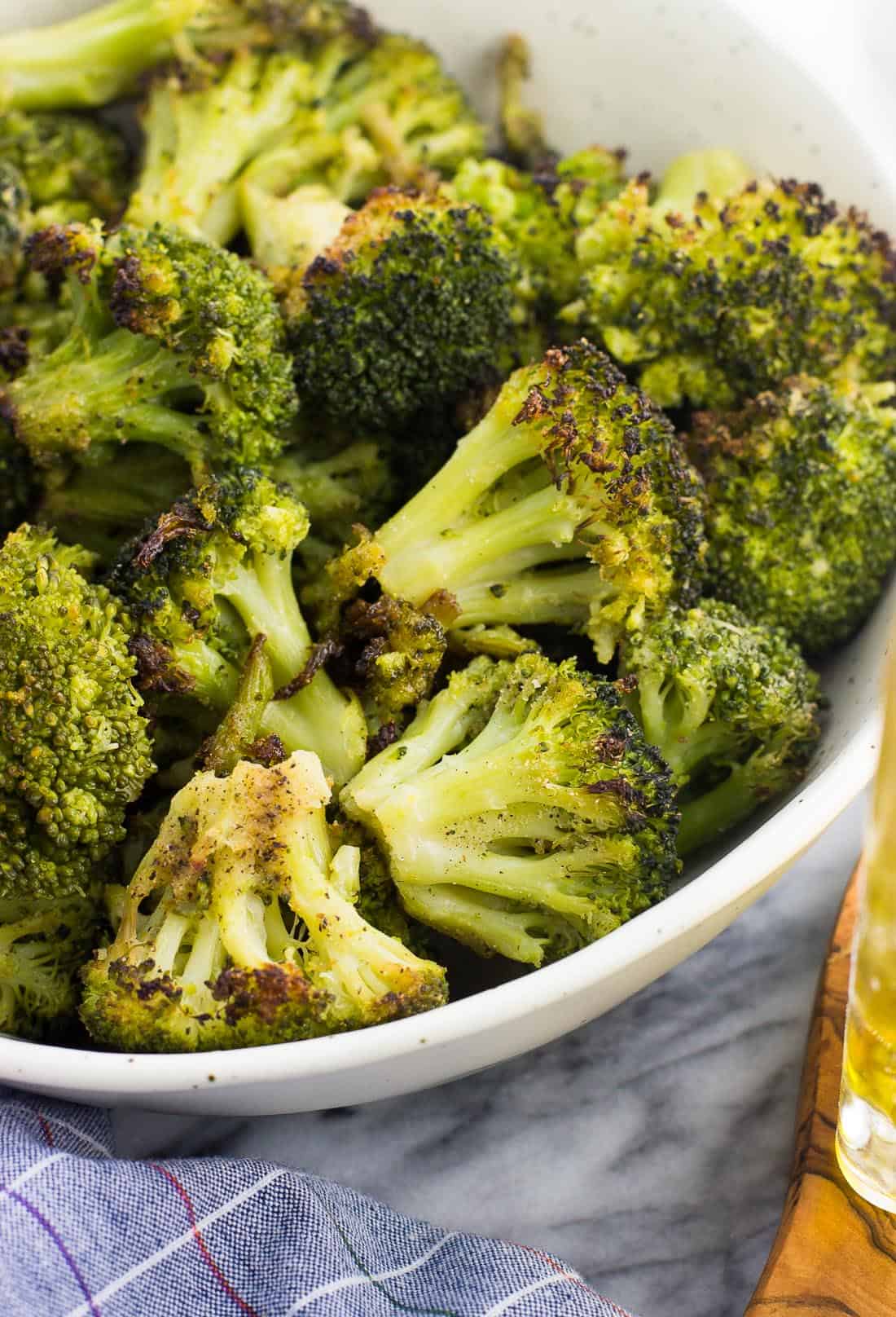 A close-up picture of oven roasted broccoli in a serving bowl.