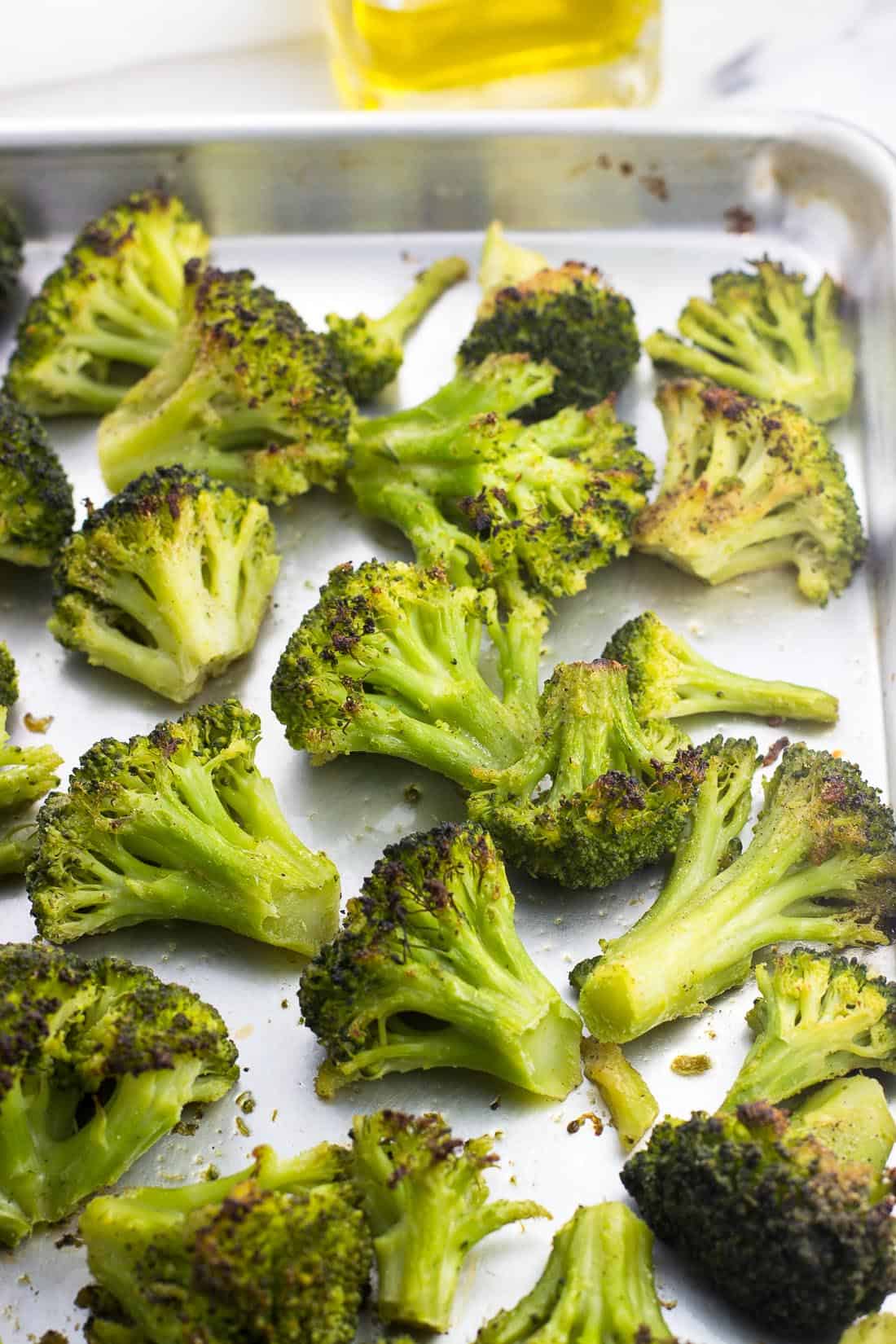 Roasted broccoli on a sheet pan after being in the oven.