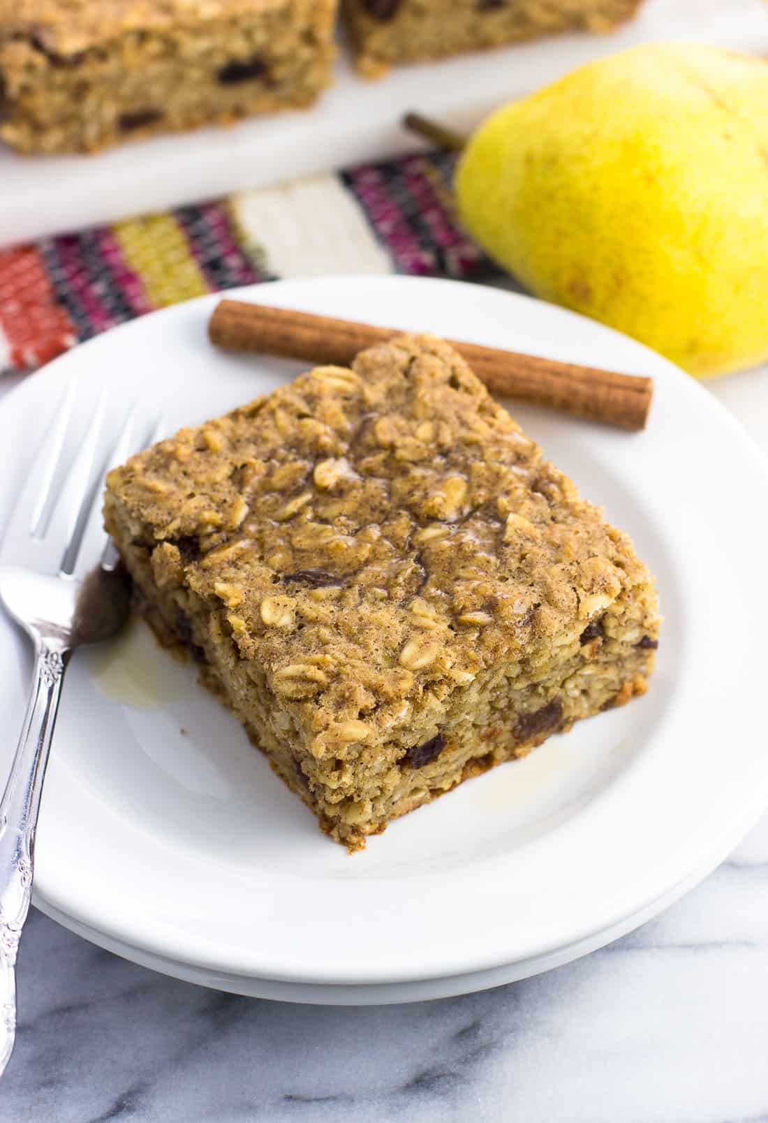 A square of peanut butter baked oatmeal on a small plate with a fork.