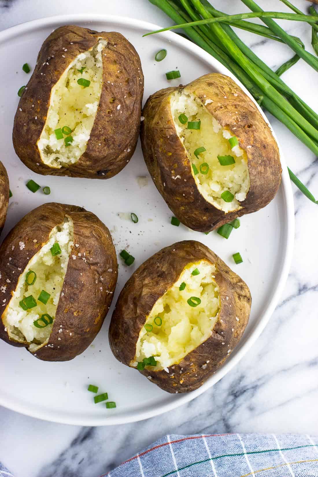 An overhead picture of air fryer baked potatoes on a plate.