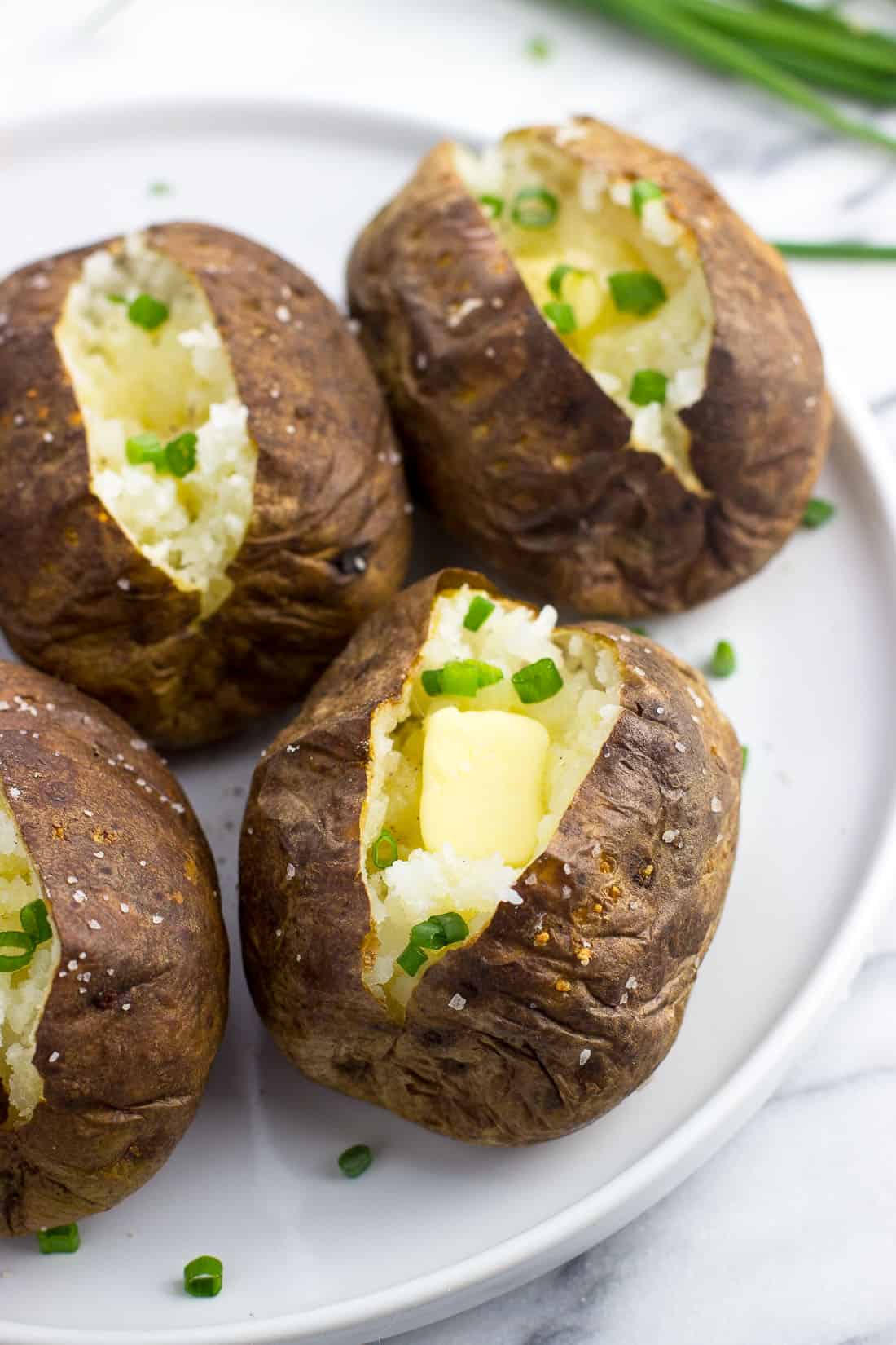 Air fryer baked potatoes on a plate.