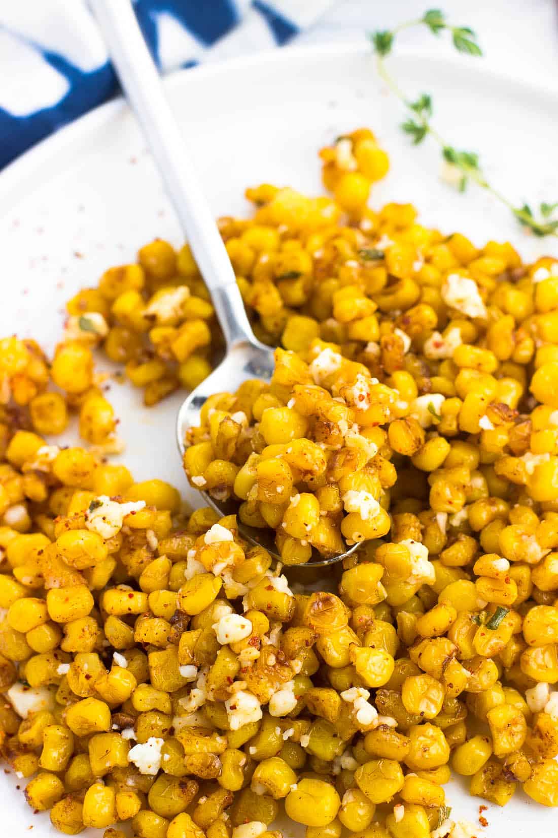 A spoon of roasted corn on a plate