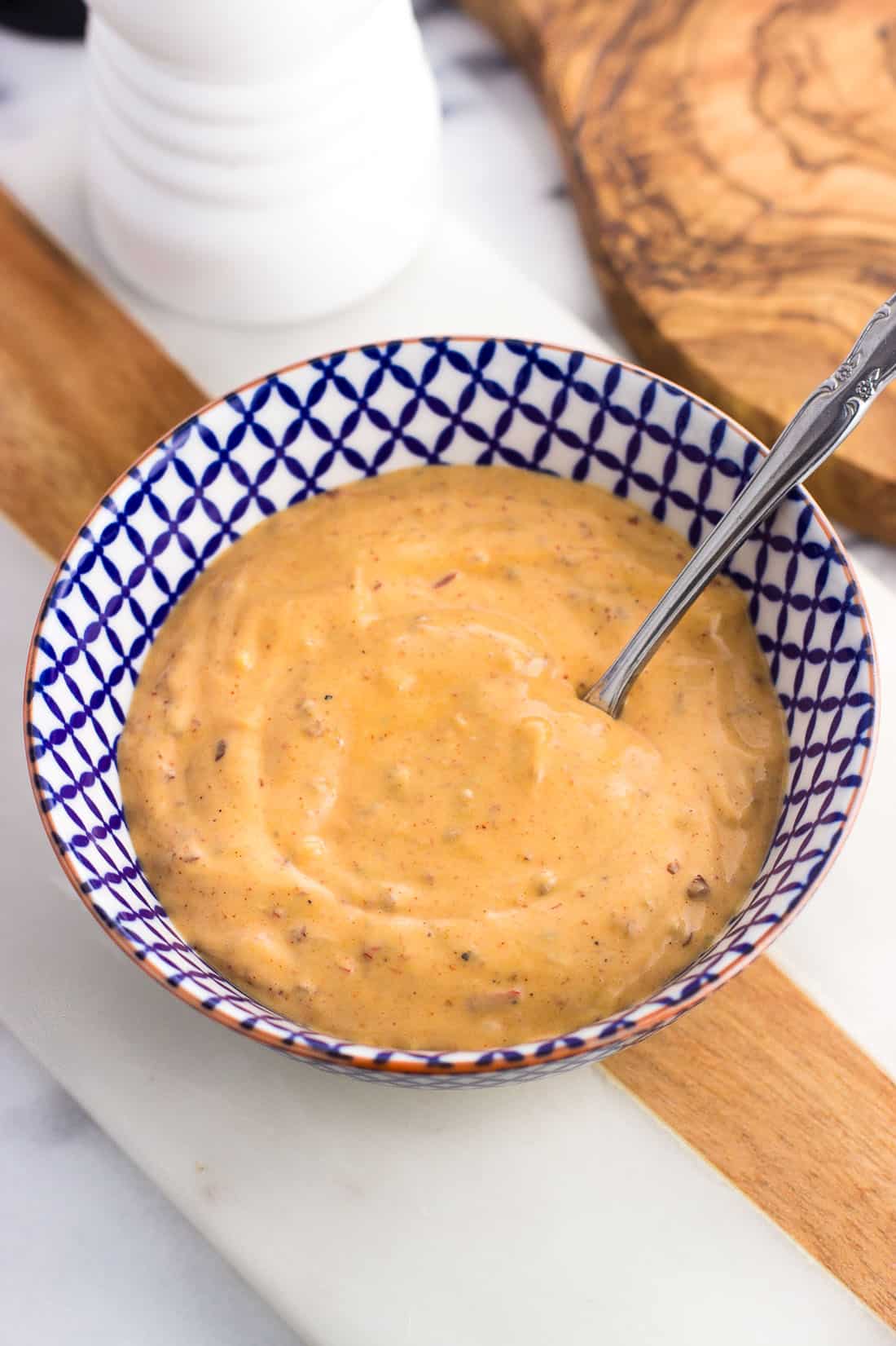 A bowl of chipotle aioli with a small spoon.