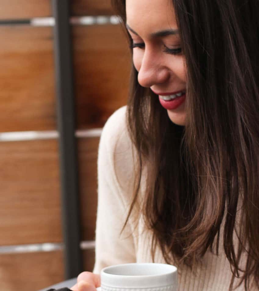 The blog author holding a cup of coffee.