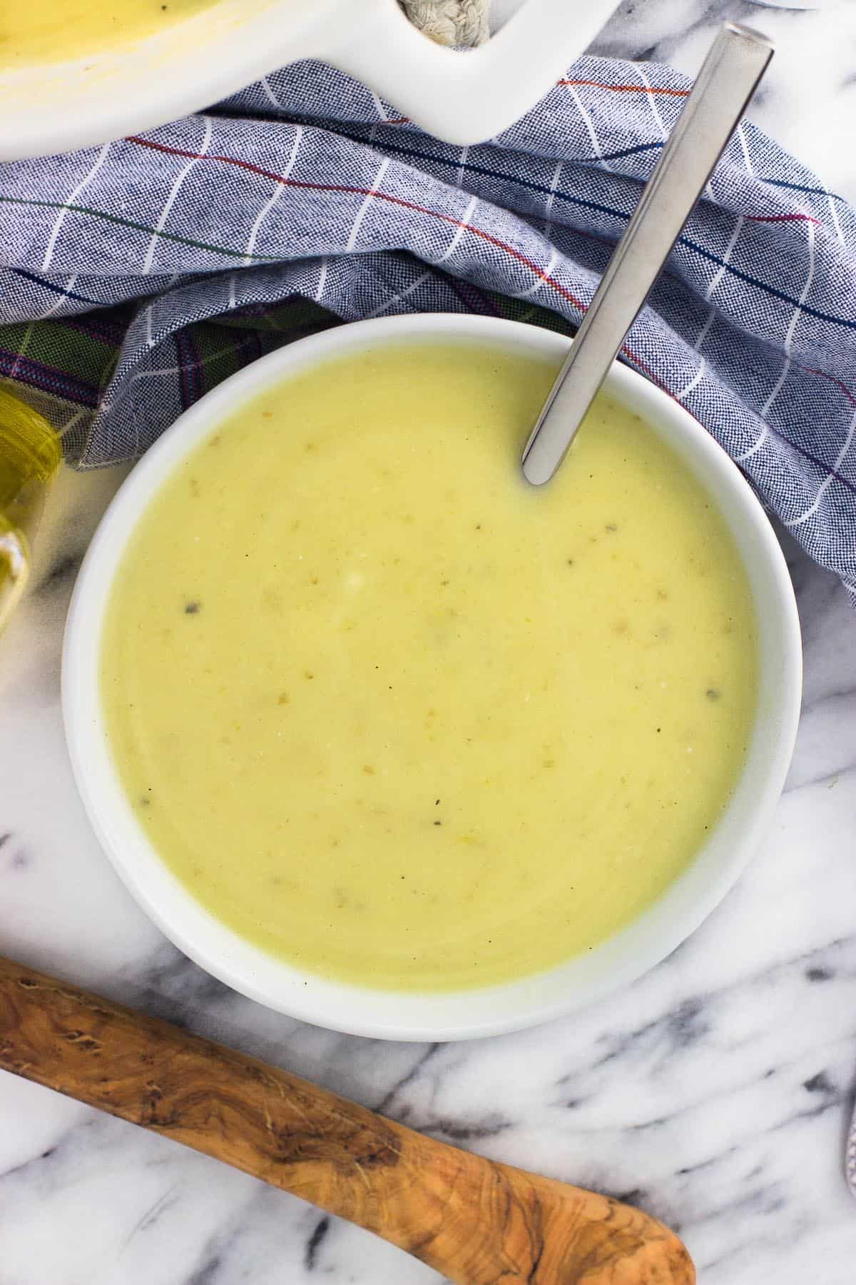 An overhead shot of soup in a ceramic soup bowl with a spoon