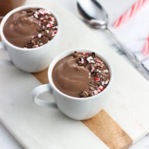 pudding in a small espresso cup garnished with chocolate curls and crushed candy canes