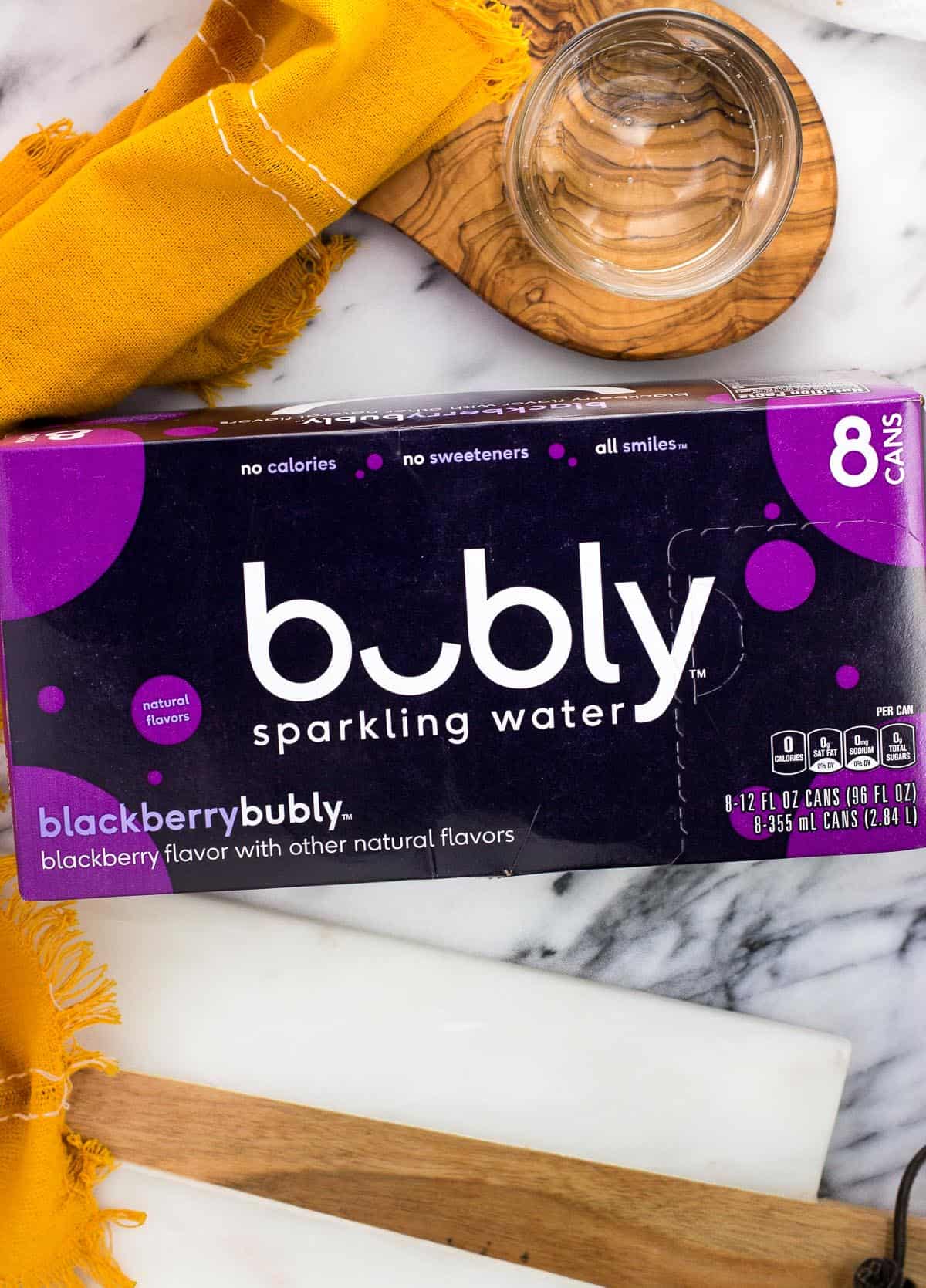 A cardboard carton of blackberry bubly water cans.