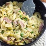 Tortellini in cream sauce with prosciutto and peas