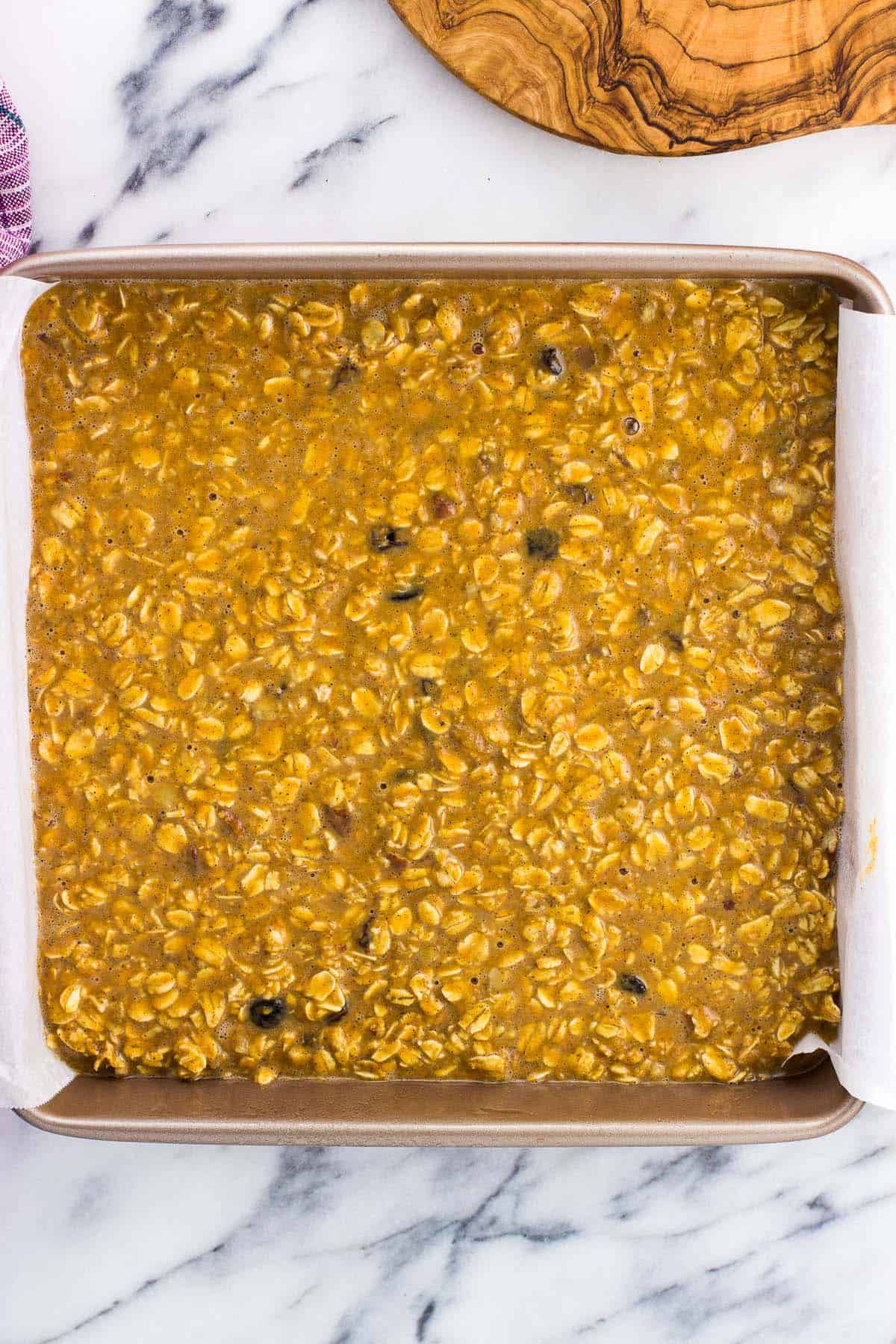 The mixture poured out into a parchment paper-lined square pan before baking