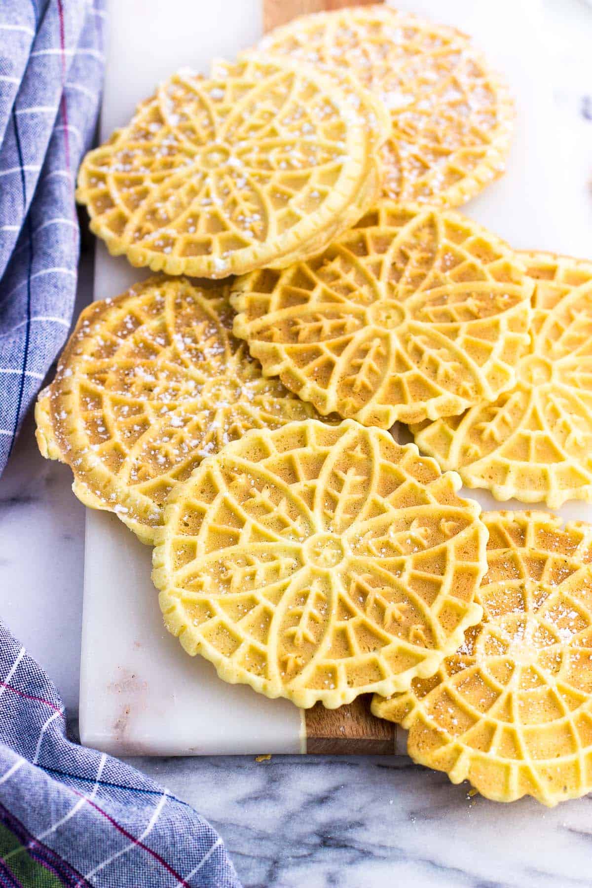 A pile of pizzelle cookies on a marble board