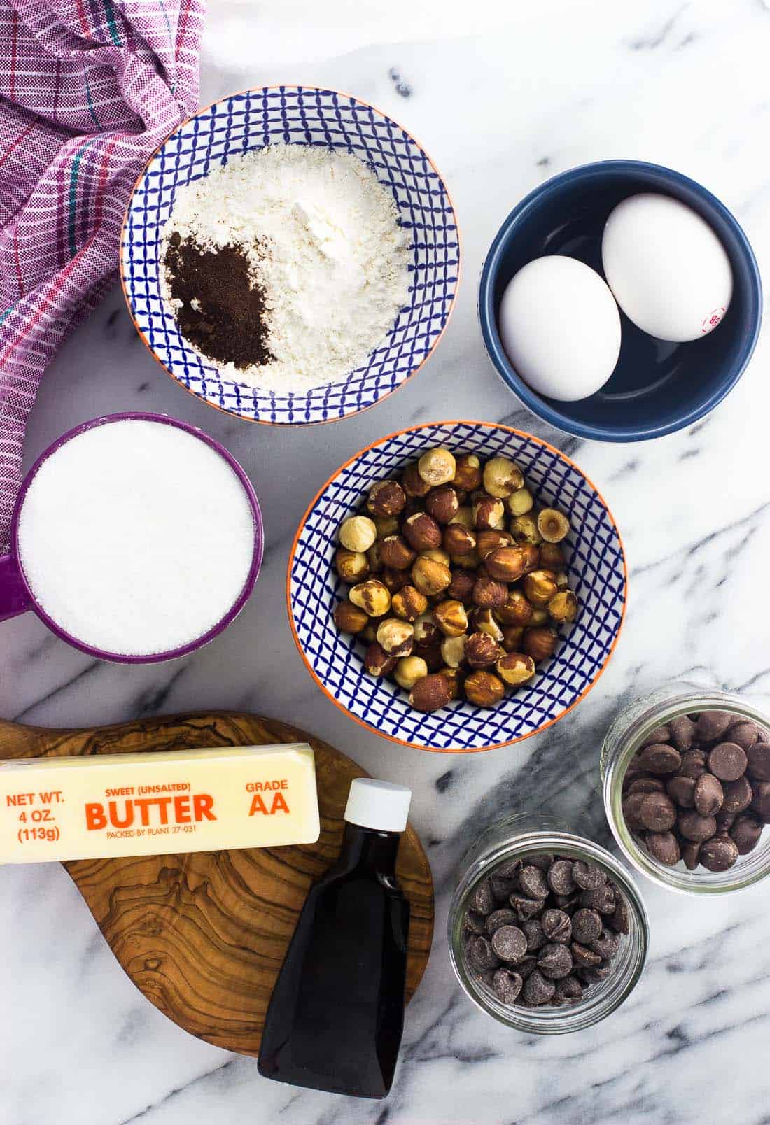 All of the chocolate hazelnut brownie ingredients in bowls on a marble board