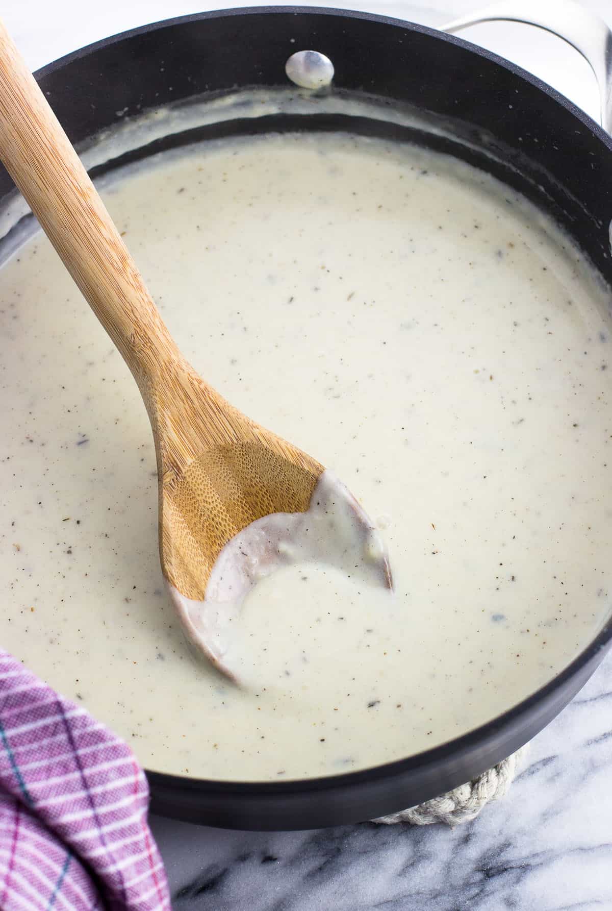 The seasoned roux in a pan with a wooden spoon