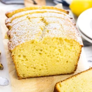 A sliced loaf of lemon yogurt cake on a marble tray.