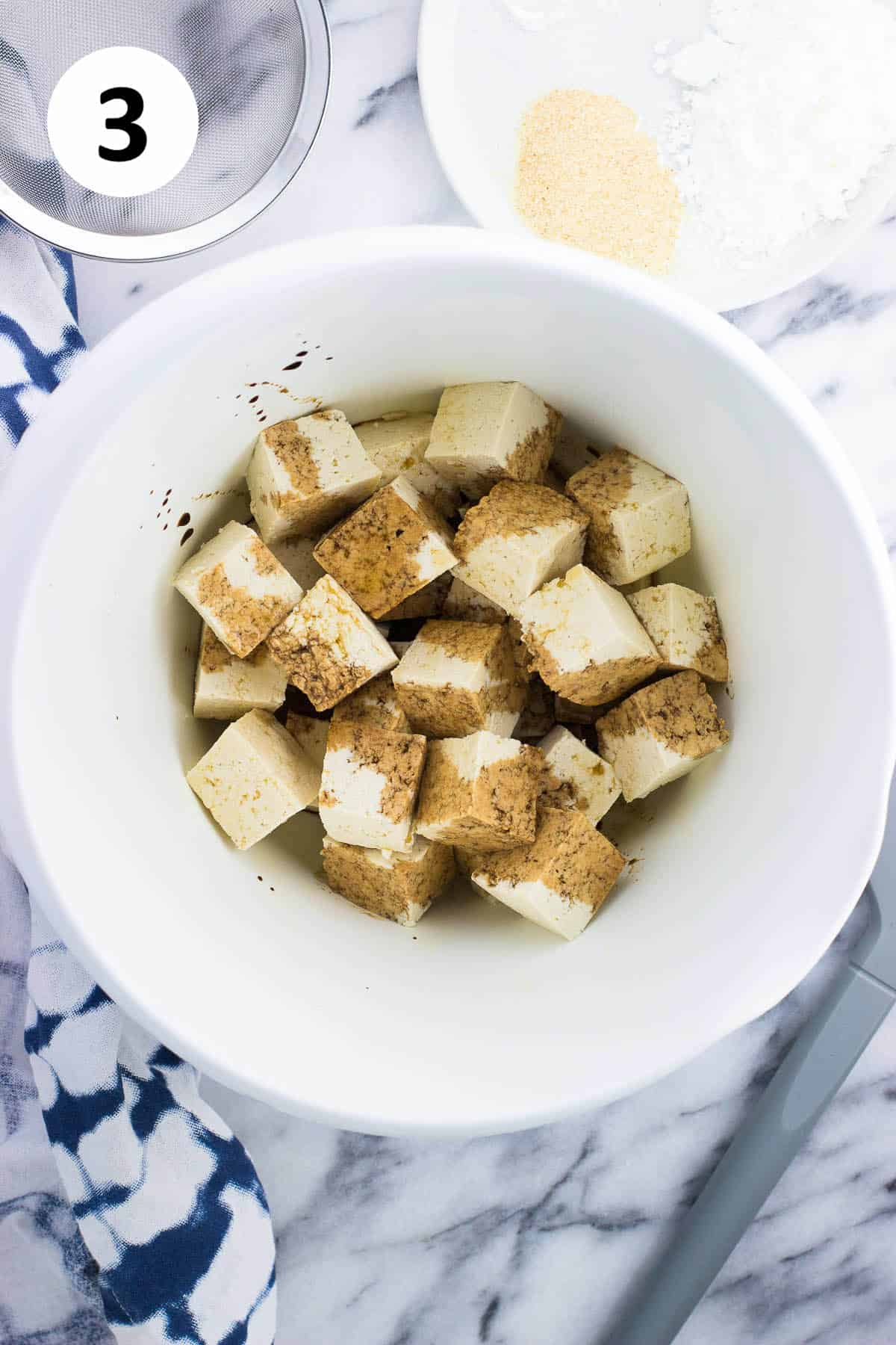 Sesame oil and soy sauce drizzled over the tofu in a bowl.