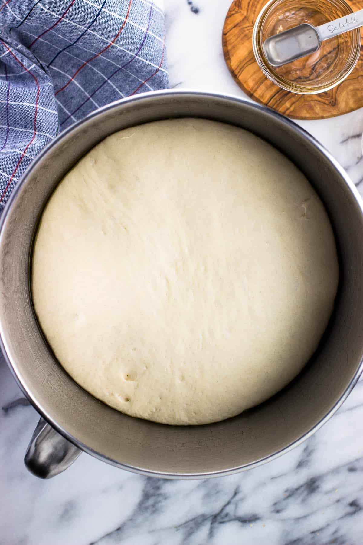 A large ball of dough in a bowl after rising.