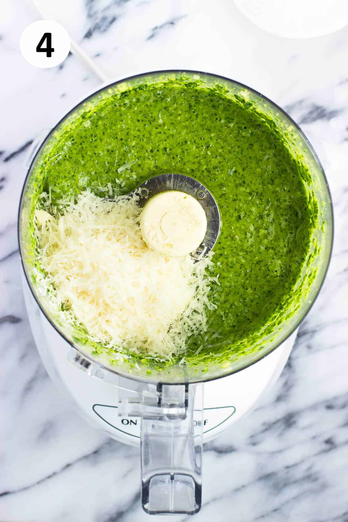 Grated Parmesan added to the pesto sauce in the food processor.